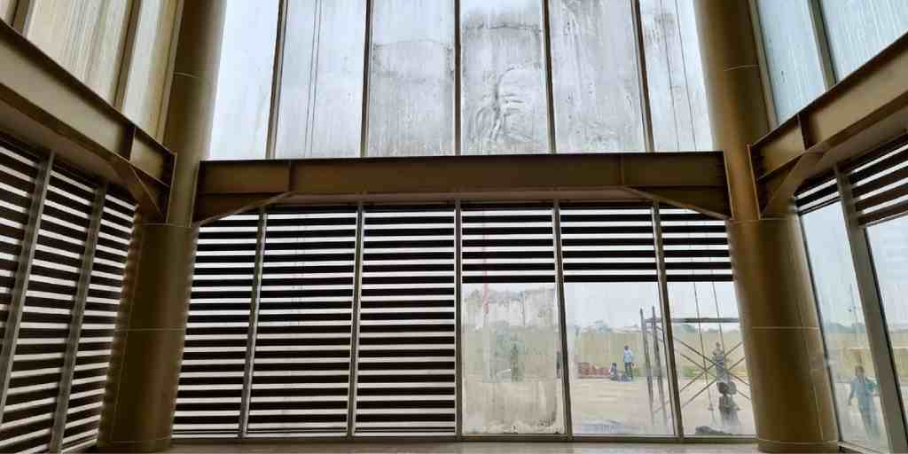 Before – atrium glass wall covered in construction dust and streaks