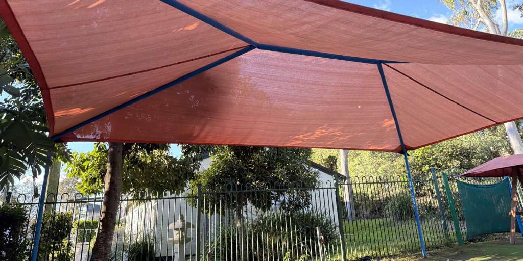 After – red outdoor park shade sail cleaned and mould treated