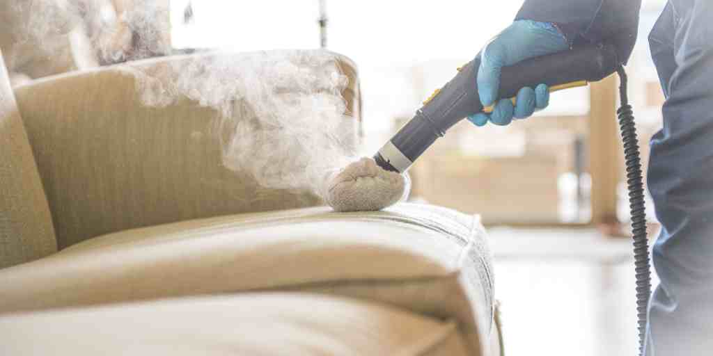 Before – upholstered armchair being steam cleaned